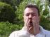 Un hombre estornudando a causa de la alergia al polen.