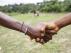 Ciudadanos de Liberia estrechan sus manos cerca de un campo escolar a las afueras de Monrovia (Liberia).
