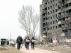 ​Varias personas caminan en Mariúpol junto a un edificio destrozado por las fuerzas rusas