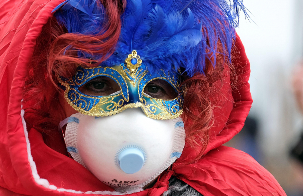 Masked carnival revellers wear protective face masks at Venice Carnival, which the last two days of, as well as Sunday night's festivities, have been cancelled because of an outbreak of coronavirus, in Venice, Italy February 23, 2020.  REUTERS/Manuel Silvestri [[[REUTERS VOCENTO]]] CHINA-HEALTH/ITALY-VENICE