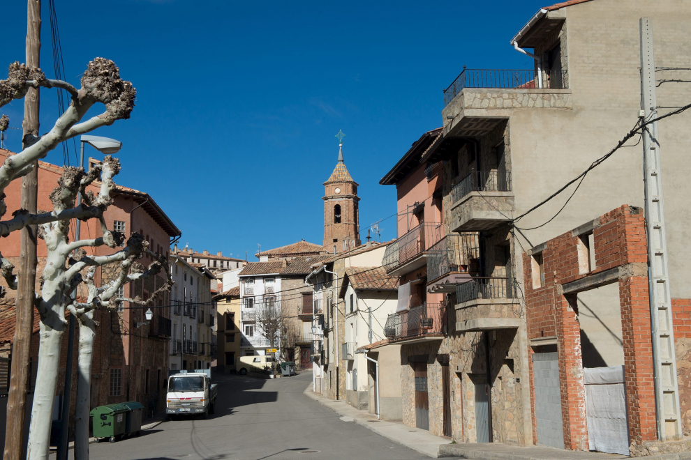 Calle con el campanario al fondo.