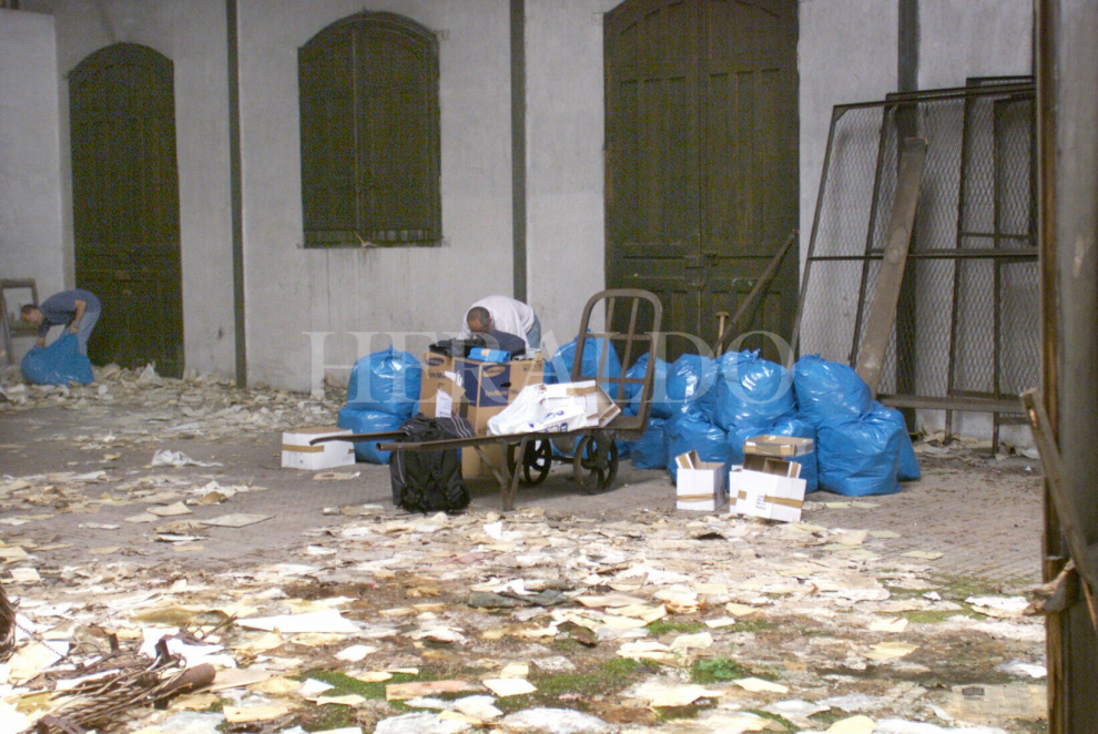 Empleados de Patrimonio de Renfe recogen los documentos abandonados en las dependencias de paquetería postal de la estación internacional de ferrocarril de Canfranc en agosto de 2001