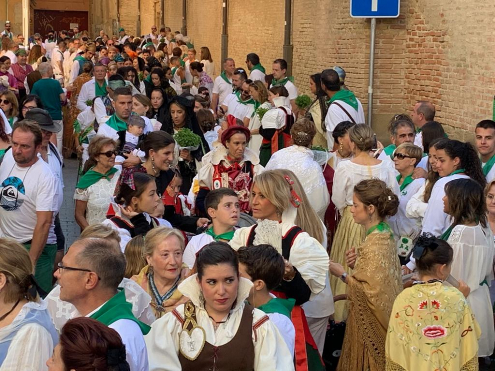 Los asistentes se incorporan desde las calles adyacentes a la plaza de San Lorenzo mientras los caballeros de la cofradía esperan la peana.