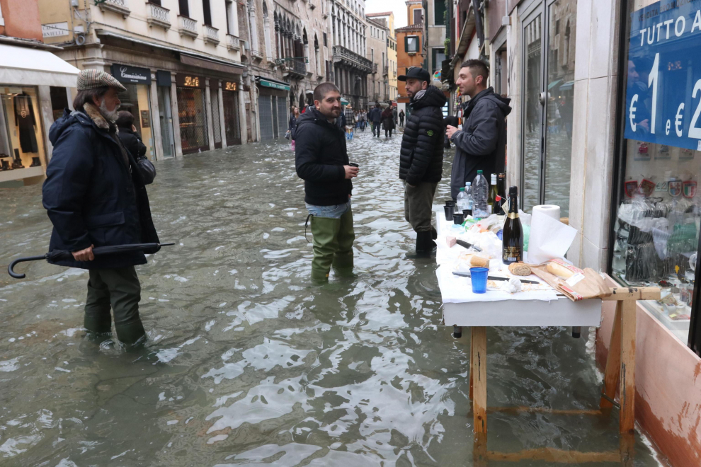 Venice (Italy), 17/11/2019.- Wearing either rubber boots, overknee waders, plastic overshoes or simply plastic bags wrapped and taped around their legs, tourists and residents resume their normal routine despite persistent flooding in Venice, Italy, 17 November 2019. High tidal waters returned to Venice on Saturday, four days after the city experienced its worst flooding in more than 50 years. (Italia, Niza, Venecia) EFE/EPA/EMILIANO CRESPI Aqua Alta in Venice