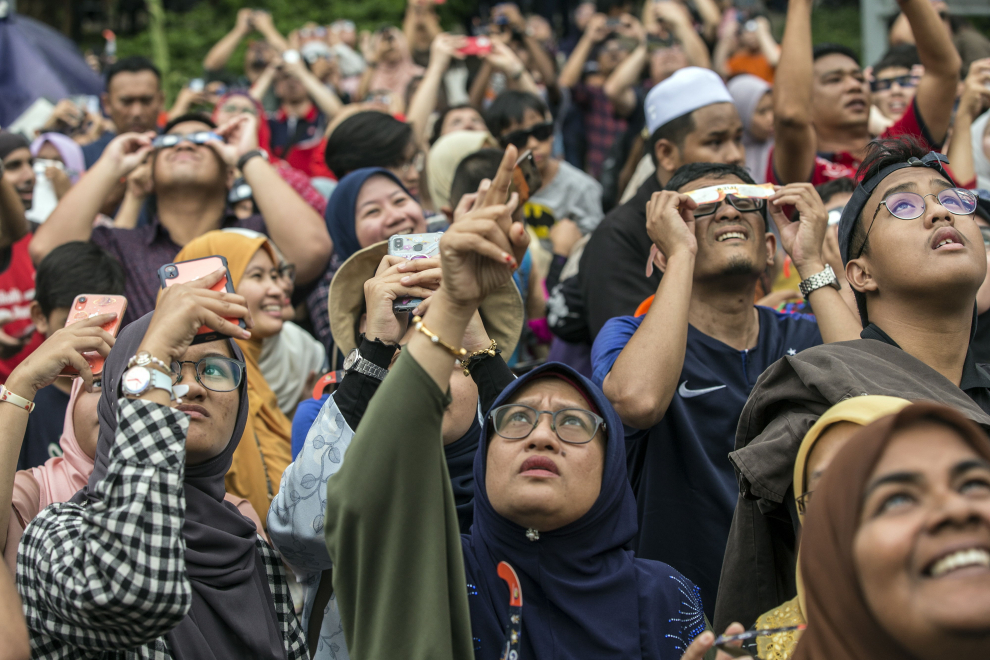 Jakarta (Indonesia), 26/12/2019.- Indonesian boys wearing special glasses look up at the sun during a solar eclipse, outside the planetarium in Jakarta, Indonesia 26 December 2019. EFE/EPA/BAGUS INDAHONO Solar eclipse in Jakarta