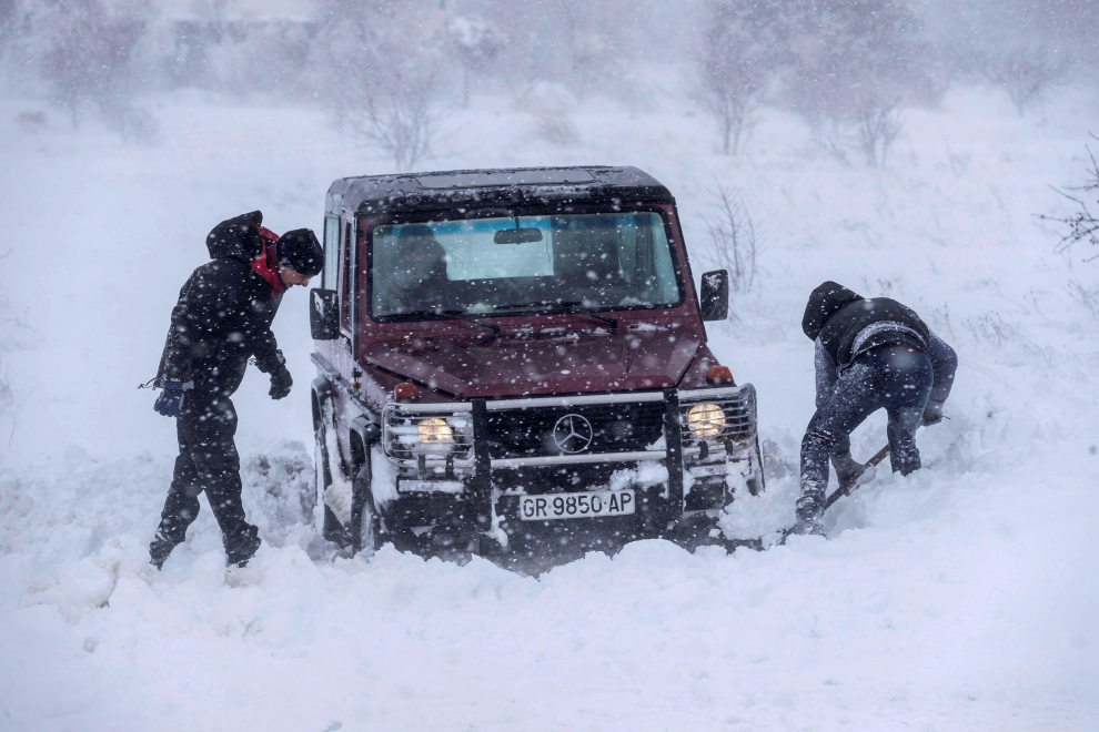 Dos personas intentan sacar su todoterreno atrapado en la nieve en las proximidades de Yecla (Murcia)