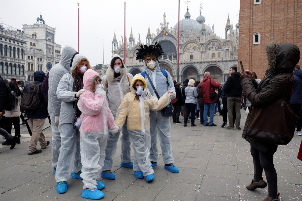 A police officer wearing a protective face mask stands next to a masked carnival reveller at Venice Carnival, which the last two days of, as well as Sunday night's festivities, have been cancelled because of an outbreak of coronavirus, in Venice, Italy February 23, 2020. REUTERS/Manuel Silvestri [[[REUTERS VOCENTO]]] CHINA-HEALTH/ITALY-VENICE