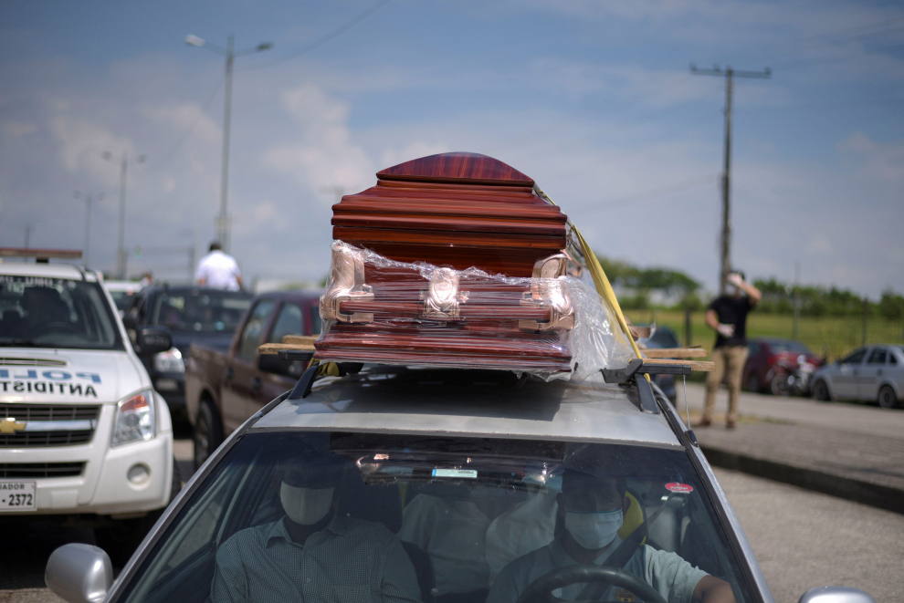 Mourners wave to a coffin in a pick-up truck entering a cemetery as Ecuador's government announced on Thursday it was building a "special camp" in Guayaquil for coronavirus disease (COVID-19) victims, in Guayaquil, Ecuador April 2, 2020. REUTERS/Vicente Gaibor del Pino NO RESALES. NO ARCHIVES [[[REUTERS VOCENTO]]] HEALTH-CORONAVIRUS/ECUADOR