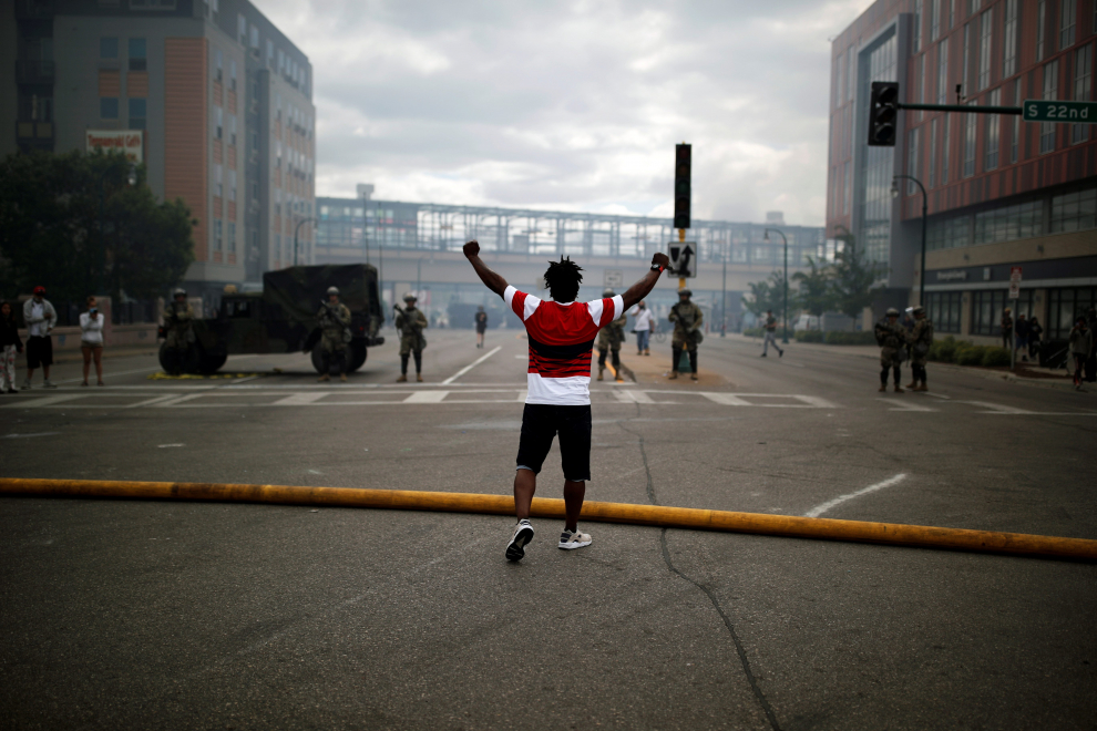 Man reacts as National Guard members guard the area in the aftermath of a protest, in Minneapolis