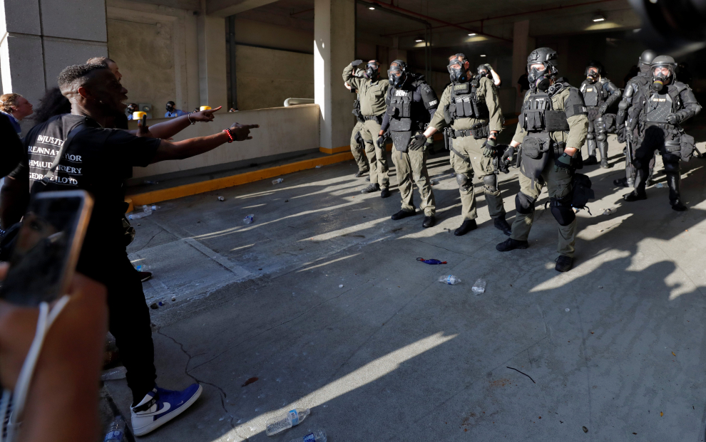 30 May 2020, US, Minneapolis: A person gestures at officers standing on the roof of the Minneapolis Police Department's during a protest over the death of George Floyd. Photo: Sait Serkan Gurbuz/ZUMA Wire/dpa30/05/2020 ONLY FOR USE IN SPAIN [[[EP]]] 30 May 2020, US, Minneapolis: A person gestures at officers standing on the roof of the Minneapolis Police Department's during a protest over the death of George Floyd. Photo: Sait Serkan Gurbuz/ZUMA Wire/dpa