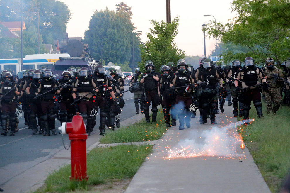 A Minneapolis police officer tells a TV cameraman to clear the area after officers launched an offensive against protesters that gathered near the Minneapolis Police fifth precinct after the death in Minneapolis police custody of George Floyd, in Minneapolis, Minnesota, U.S. May 30, 2020. Picture taken May 30, 2020. REUTERS/Adam Bettcher [[[REUTERS VOCENTO]]] MINNEAPOLIS-POLICE/