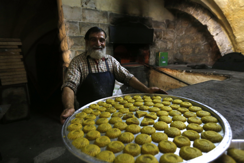 Nablus (-), 29/07/2020.- Palestinian baker works to prepare traditional kahk called (Ma'amoul ) inside an old bakery in the old city of Nablus in preparation for the Muslim festival of Eid al-Adha in the West Bank city of Nablus, 29 July 2020. Eid al-Adha is the holiest of the two Muslims holidays celebrated each year, it marks the yearly Muslim pilgrimage (Hajj) to visit Mecca, the holiest place in Islam. Muslims slaughter a sacrificial animal and split the meat into three parts, one for the family, one for friends and relatives, and one for the poor and needy. (La meca) EFE/EPA/ALAA BADARNEH ATTENTION: This Image is part of a PHOTO SET Eid al-Adha preparations in Nablus