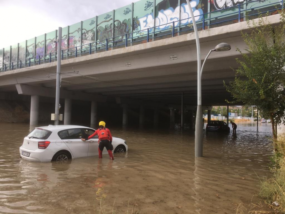 Intervención de los Bomberos de Zaragoza en la calle Luciano Gracia del Actur para ayudar a los coches afectados por la tromba de agua.