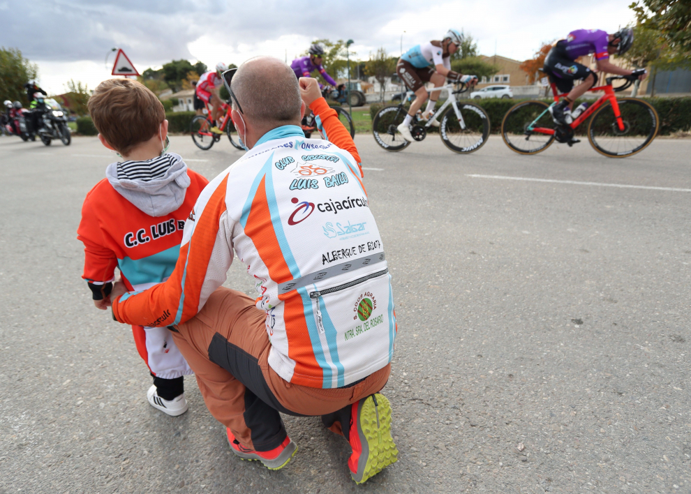 n hombre y un niño observan el paso del pelotón durante la cuarta etapa de la Vuelta Ciclista a España, entre Garray y Ejea de los Caballeros