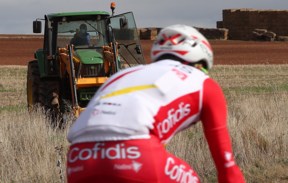 Un tractor observa el paso de uno de los ciclistas participantes en la cuarta etapa de la Vuelta que se disputa hoy entre Garray Numancia y Ejea de los Caballeros