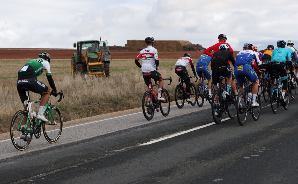 Un tractor observa el paso de uno de los ciclistas participantes en la cuarta etapa de la Vuelta que se disputa hoy entre Garray Numancia y Ejea de los Caballeros