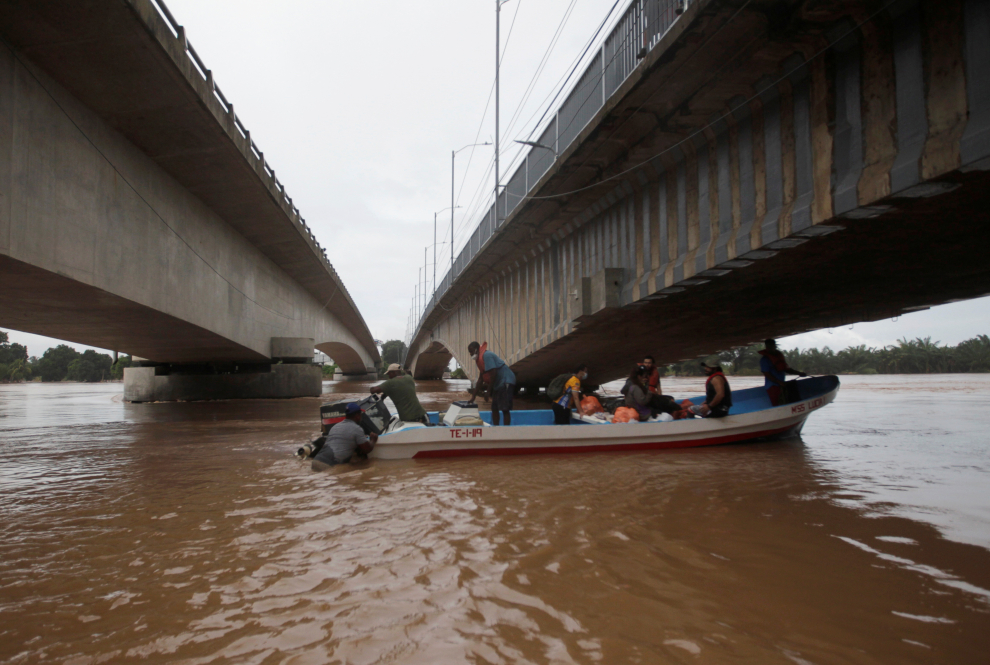 A man carries his belongings through a flooded road after the passing of Storm Iota, in Marcovia, Honduras November 18, 2020. REUTERS/Jorge Cabrera[[[REUTERS VOCENTO]]] STORM-IOTA/