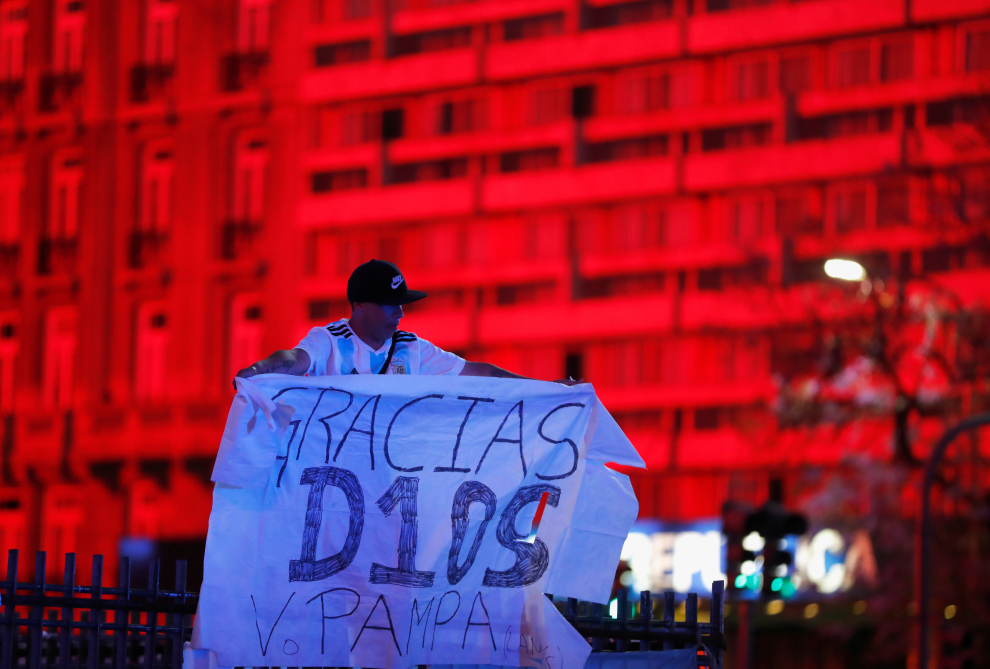 A fan holds a banner as people gather to mourn the death of Argentine soccer great Diego Maradona at the Obelisk of Buenos Aires, Argentina November 25, 2020. The banner reads as Thank SOCCER-ARGENTINA/MARADONA