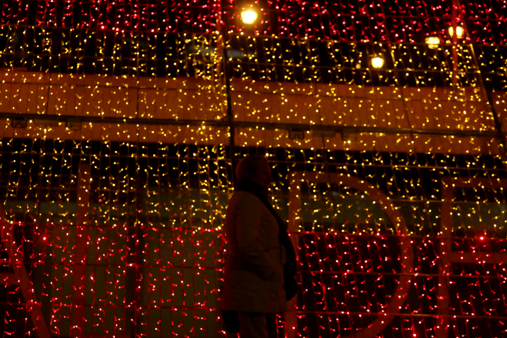 A woman stands beside a part of one kilometre-long Christmas illuminations with the colours of the Spanish flag, amid the coronavirus disease (COVID-19) outbreak in Madrid, Spain, November 26, 2020. REUTERS/Sergio Perez[[[REUTERS VOCENTO]]] CHRISTMAS-SEASON/SPAIN-LIGHTS