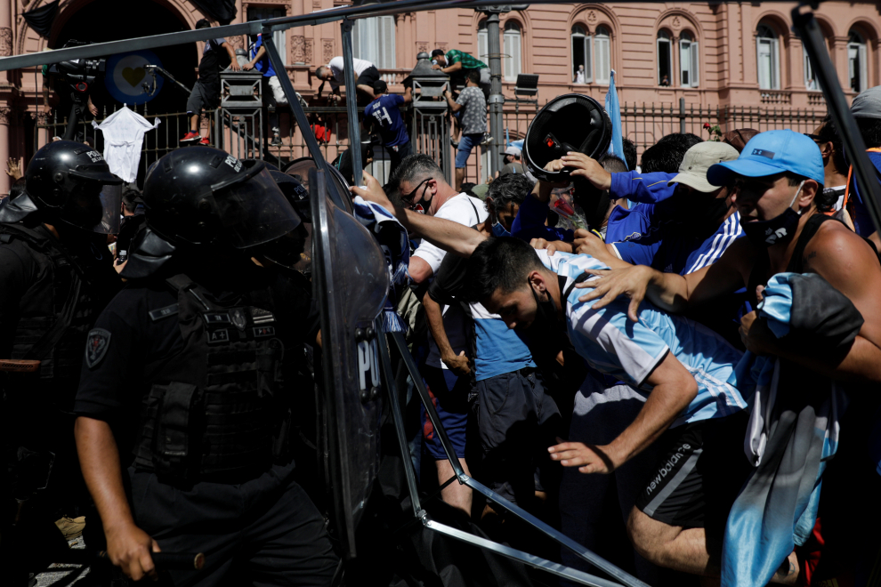A man gestures as riot police try to disperse people gathering in front of the Casa Rosada presidential palace to mourn the death of soccer legend Diego Armando Maradona, in Buenos Aires, Argentina November 26, 2020. REUTERS/Ricardo Moraes[[[REUTERS VOCENTO]]] SOCCER-ARGENTINA/MARADONA