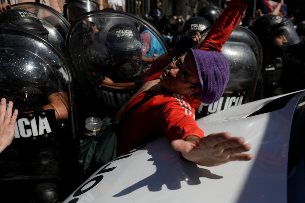 People gesture as riot police try to disperse them in front of the Casa Rosada presidential palace as they gather to mourn the death of soccer legend Diego Armando Maradona, in Buenos Aires, Argentina November 26, 2020. REUTERS/Ricardo Moraes[[[REUTERS VOCENTO]]] SOCCER-ARGENTINA/MARADONA