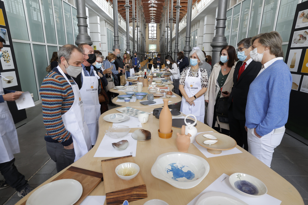 Representantes de los artesanos, de los cocineros y del Gobierno autónomo observan las colecciones de vajillas.