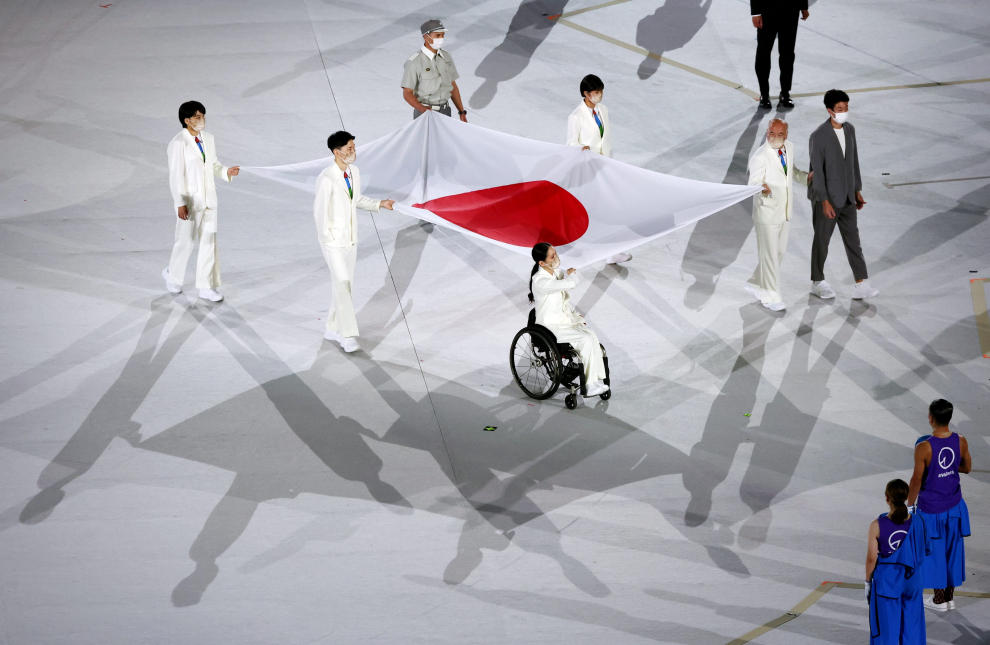 Tokyo 2020 Paralympic Games - The Tokyo 2020 Paralympic Games Opening Ceremony - Olympic Stadium, Tokyo, Japan - August 24, 2021. Healthcare workers present the Japanese flag REUTERS/Bernadett Szabo[[[REUTERS VOCENTO]]] PARALYMPICS-2020/CEREMONY