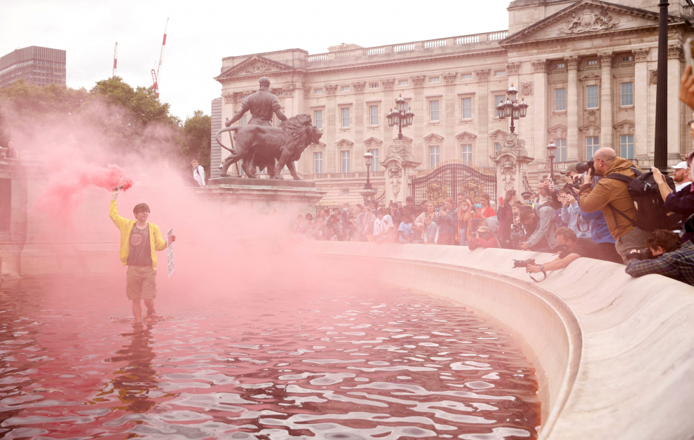 An Extinction Rebellion activist holds a placard in a fountain stained with fake blood during a protest next to Buckingham Palace in London, Britain, August 26, 2021. REUTERS/John Sibley[[[REUTERS VOCENTO]]] CLIMATE-CHANGE/BRITAIN-PROTESTS