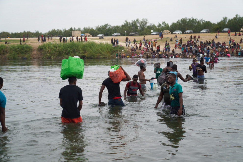 Ciudad Acuna (Mexico), 21/09/2021.- Migrants cross the Rio Grande river from the United States back to Mexico, to camp after a lack of supplies are given to them in the USA in Ciudad Acuna, Mexico, 21 September 2021. According to reports more than 14,000 people have crossed the Rio Grande river from Mexico creating a humanitarian crisis. The Biden administration has started to fly the migrants back to Haiti according to federal officials. (Estados Unidos) EFE/EPA/ALLISON DINNER
 MEXICO USA MIGRATION