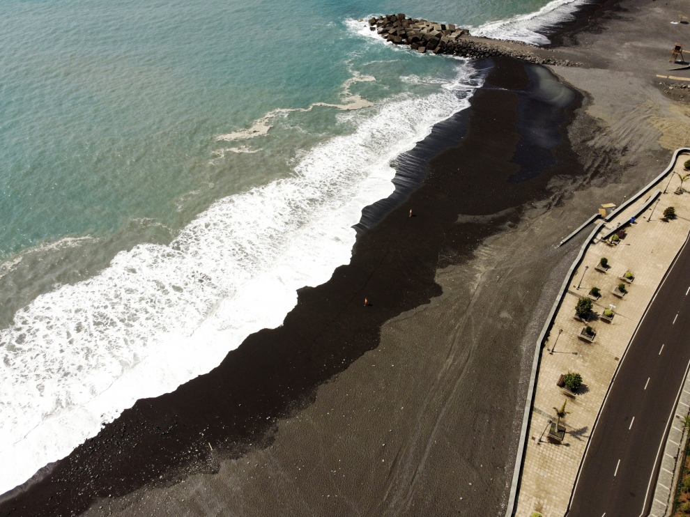 Tourists sunbathe on an empty Puerto de Tazacorte beach, near the volcano that is erupting in the Cumbre Vieja national park, in Tazacorte, on the Canary Island of La Palma, Spain September 24, 2021. Picture taken with drone. REUTERS/Nacho Doce[[[REUTERS VOCENTO]]] SPAIN-VOLCANO/