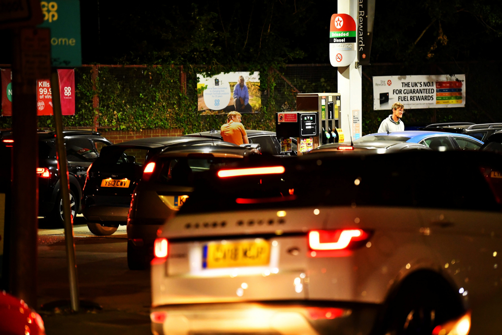 People push as a car, which has run out of petrol, the final few meters on to the forecourt as vehicles queue to refill at a Texaco fuel station in south London, Britain, September 26, 2021.  Picture taken September 26, 2021.  REUTERS/Dylan Martinez[[[REUTERS VOCENTO]]] POWER-PRICES/BRITAIN