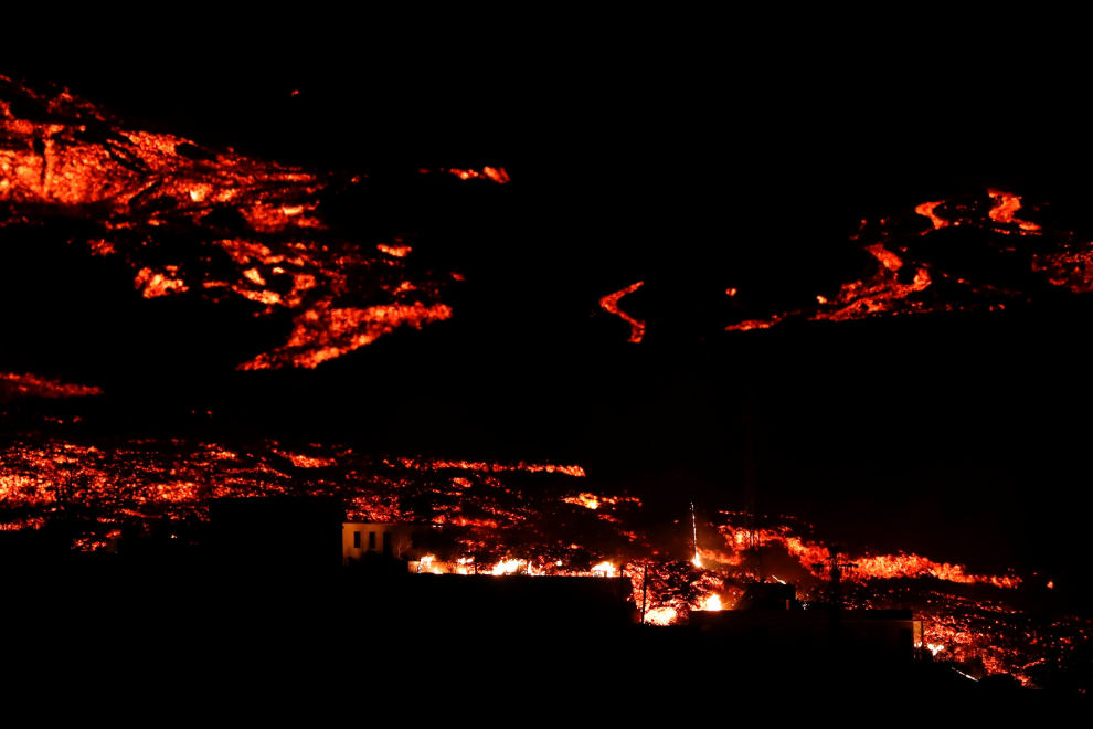 Lava from the Cumbre Vieja volcano flows among houses on the Canary Island of La Palma, as seen from Tajuya, Spain, October 19, 2021. REUTERS/Susana Vera[[[REUTERS VOCENTO]]] SPAIN-VOLCANO/