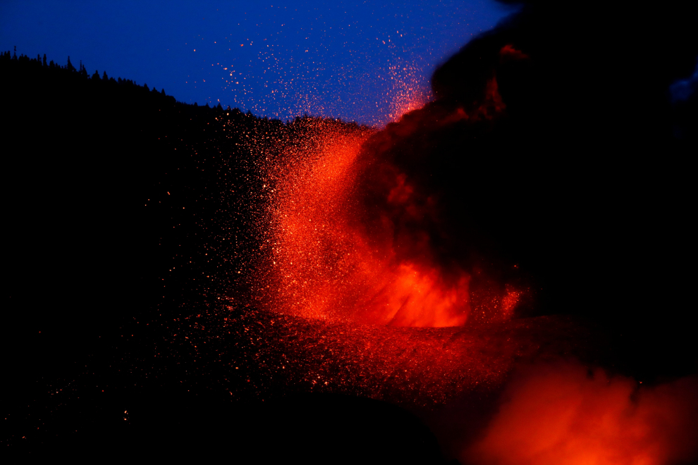 Lava from the Cumbre Vieja volcano surrounds a house on the Canary Island of La Palma, as seen from Tajuya, Spain, October 19, 2021. REUTERS/Susana Vera[[[REUTERS VOCENTO]]] SPAIN-VOLCANO/