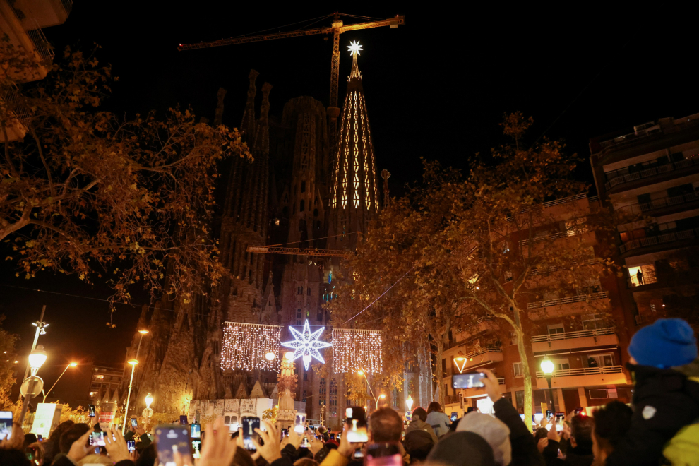 People gather near Sagrada Familia, as a luminous star is lit on one of the towers of architect Antoni Gaudi's masterpiece, in Barcelona, Spain December 8, 2021. REUTERS/Nacho Doce SPAIN-CULTURE/SAGRADA FAMILIA