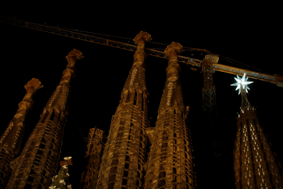 People take photos as a luminous star is lit on a tower of the Sagrada Familia, the newest addition to architect Antoni Gaudi's masterpiece, in Barcelona, Spain December 8, 2021. REUTERS/Nacho Doce SPAIN-CULTURE/SAGRADA FAMILIA