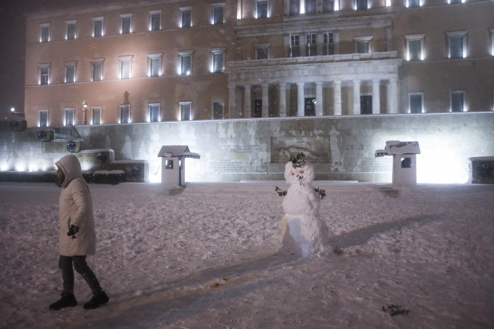 Athens (Greece), 24/01/2022.- People play with the snow outside the Greek parliament in central Athens, Greece, 24 January 2022. A cold weather front, named 'Elpis' by the National Meteorological Services (EMY), has caused frozen temperatures, stormy winds and heavy snowfall since 22 January. A second and even more severe 'Elpis' has started on 24 January and is expected to continue on 25 January. (Grecia, Atenas) EFE/EPA/GEORGE VITSARAS
 GREECE WEATHER SNOW