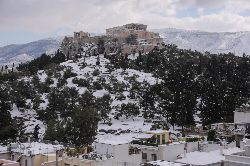Athens (Greece), 25/01/2022.- A woman shovelling snow on the roof of her apartment after heavy snowfall in Athens, Greece, 25 January 2022. A bad weather front, named Elpis by the National Meteorological Services (EMY), has caused frozen temperatures, stormy winds and heavy snowfall since 22 January. (Grecia, Atenas) EFE/EPA/GEORGE VITSARAS
 GREECE WEATHER SNOW