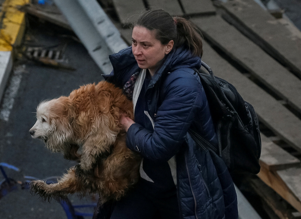 A woman carries her dog during an evacuation, as Russia's invasion of Ukraine continues, in the town of Irpin