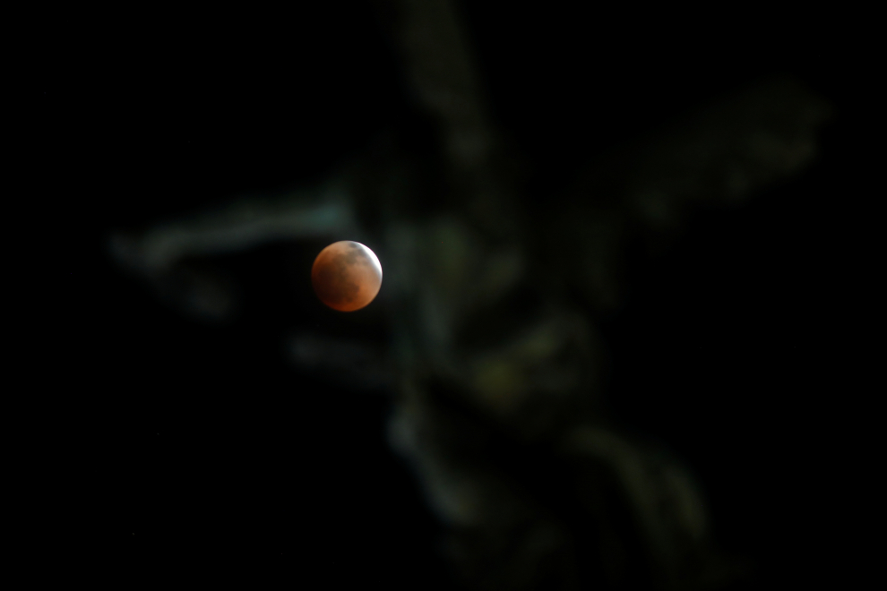 A full moon moves through the shadow of the earth during a "Blood Moon" lunar eclipse in San Salvador