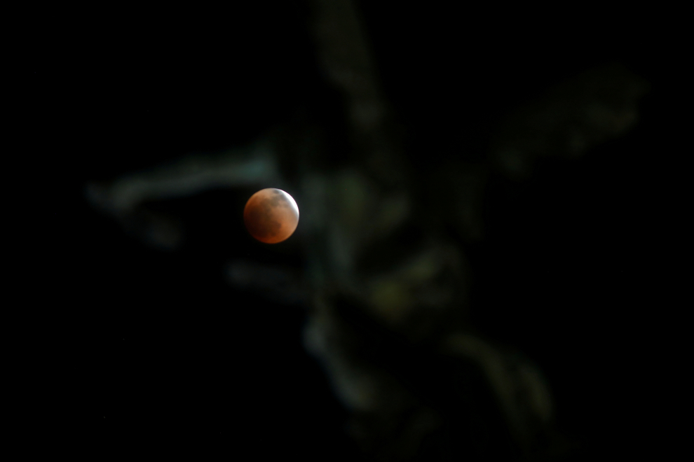 A full moon moves through the shadow of the earth during a "Blood Moon" lunar eclipse in San Salvador