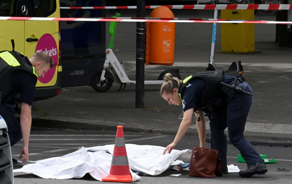 Berlin (Germany), 08/06/2022.- A police officer stands next to the covered body of a person after a car drove into a crowd of people in central Berlin, Germany, 08 June 2022. According to police, a man is said to have driven into a group of people in central Berlin. One person died and several others were injured in the accident. (Alemania) EFE/EPA/FILIP SINGER
 GERMANY BERLIN CAR PLOWS INTO CROWD