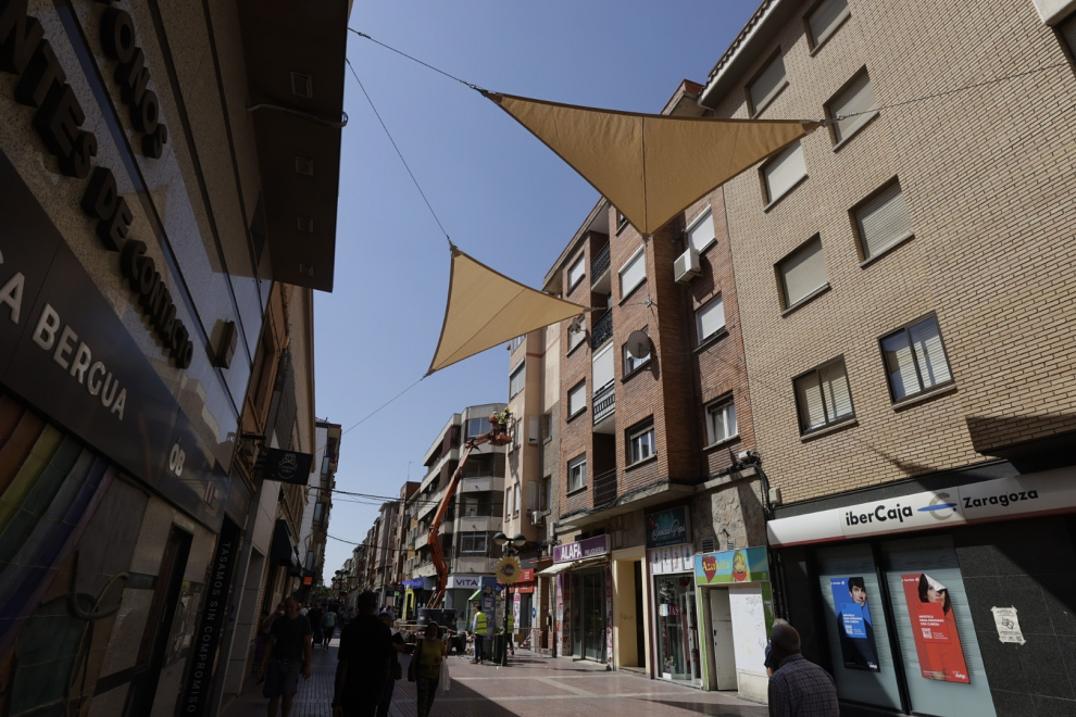 La comercial calle de Delicias en Zaragoza comienza a lucir este lunes una imagen más moderna y fresca gracias a la colocación de 50 toldos triangulares a lo largo de toda la vía color arena.