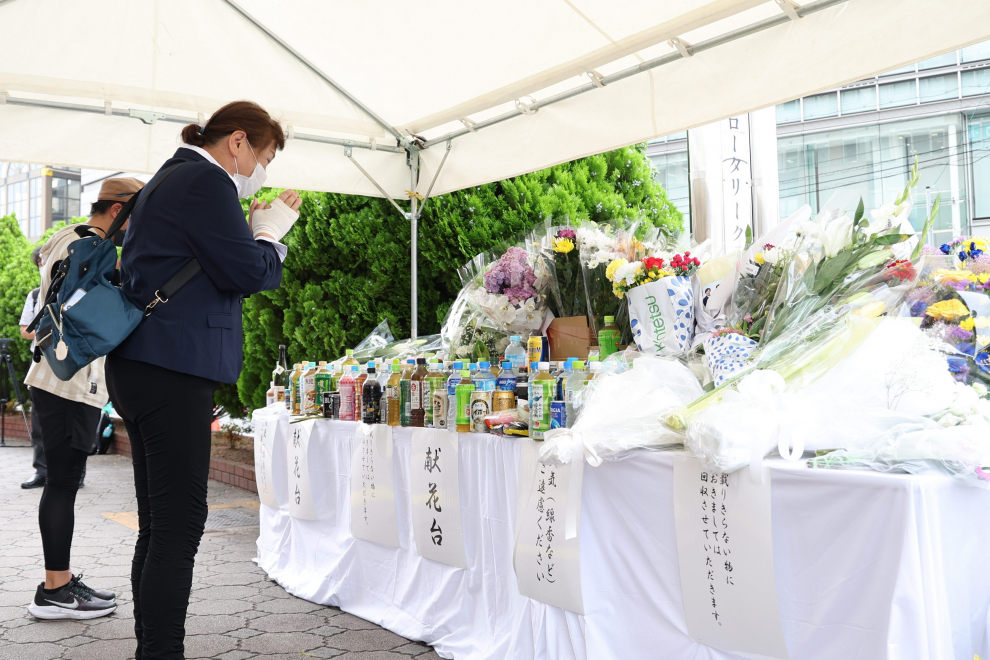 A man holds a bouquet to mourn former Japanese Prime Minister Shinzo Abe, who was shot while campaigning for a parliamentary election, in front of his residence in Tokyo, Japan July 9, 2022. REUTERS/ Kim Kyung-Hoon JAPAN-ABE/