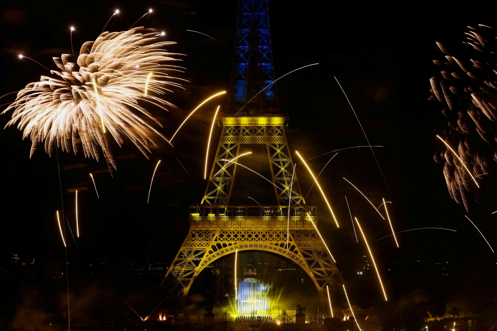 Fireworks explode around the Eiffel Tower, lighted with the colors of Ukraine, during celebrations to mark Bastille Day, in Paris, France, July 14, 2022. REUTERS/Benoit Tessier FRANCE-NATIONALDAY/FIREWORKS
