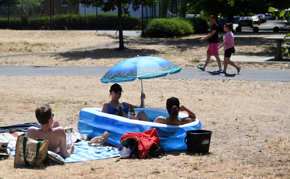 London (United Kingdom), 18/07/2022.- Friends sit in a kiddies paddling pool after a council parks vehicle filled their pool with water at a park in central London, Britain, 18 July 2022. The Met Office has issued a red extreme heat warning as the UK could have its hottest day on record this week, with temperatures forecast to hit up to 41 Celsius. (Reino Unido, Londres) EFE/EPA/ANDY RAIN
BRITAIN WEATHER
