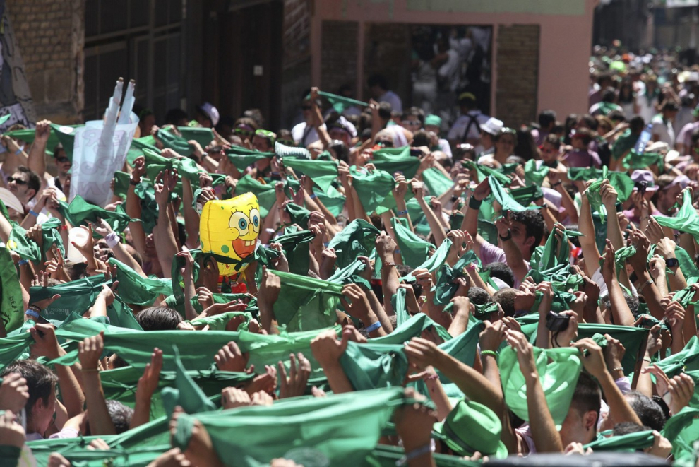 Saludo al santo. Cientos de peñistas alzan sus pañoletas verdes para saludar la santo delante de la basílica.
