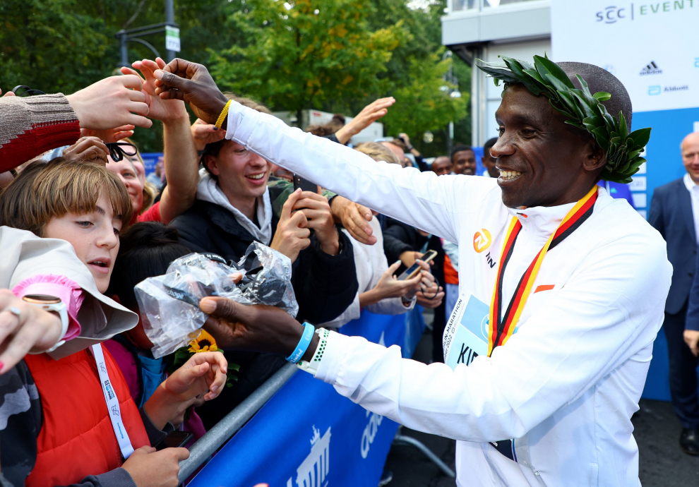 Athletics - Berlin Marathon - Berlin, Germany - September 25, 2022 Kenya's Eliud Kipchoge celebrates winning the Berlin Marathon alongside a clock showing his World Record breaking time REUTERS/Fabrizio Bensch ATHLETICS-BERLIN/