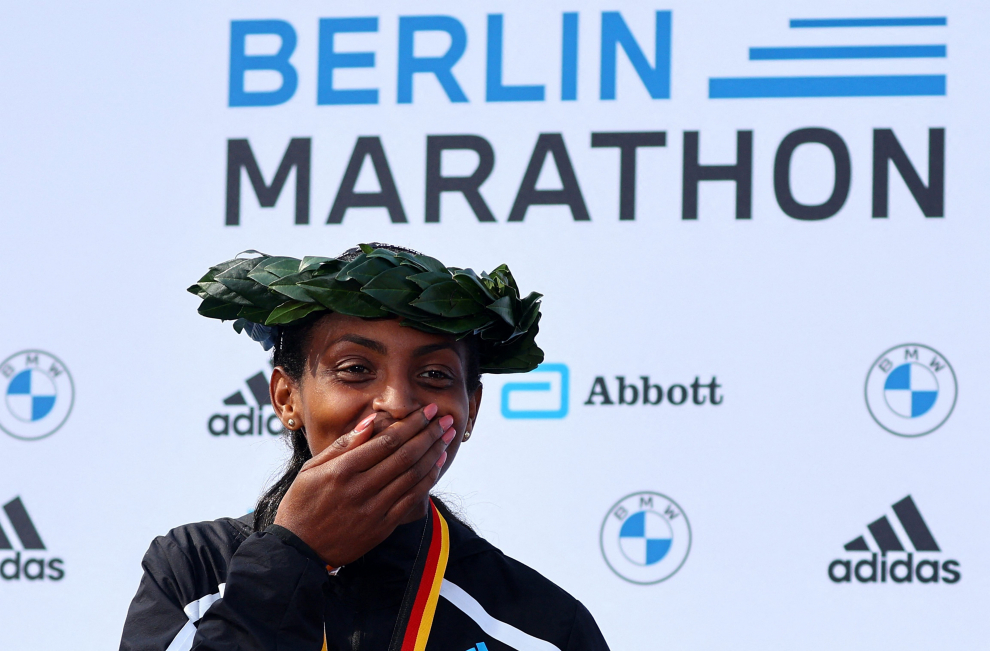 Athletics - Berlin Marathon - Berlin, Germany - September 25, 2022 Kenya's Eliud Kipchoge celebrates on the podium after winning the Berlin Marathon and breaking the World Record with elite women's race winner Ethiopia's Tigist Assefa REUTERS/Fabrizio Bensch ATHLETICS-BERLIN/