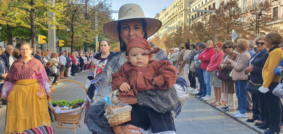 Maria José Gracia y Tiago, de tan solo 8 meses, lleva una magdalena de chocolate a la virgen.