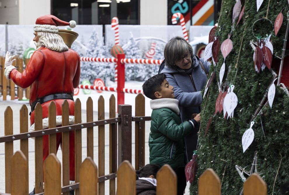 La iluminación navideña y la feria de la plaza del Pilar llenan las calles y las tiendas pese al frío.